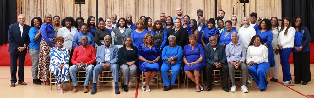 Prichard Housing Authority Full Staff posing in cordinated colors for a photo smiling at the camera