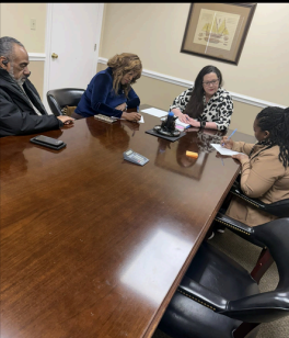 Homeownership Closing, several people seated around a desk signing paperwork
