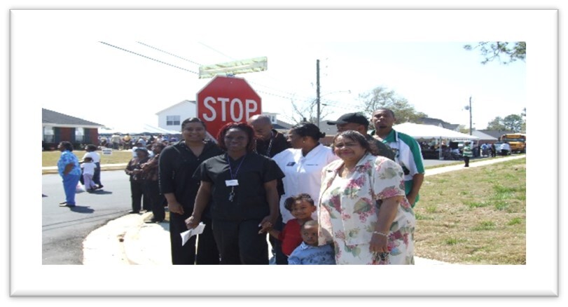 A group of people stand in front of a street sign during the Marsha S. Ratachford street dedication
